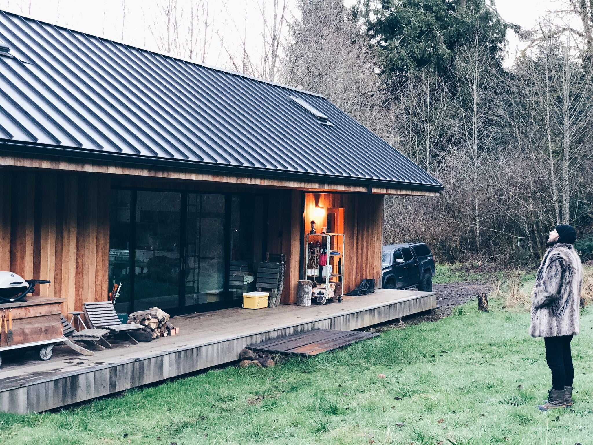 person standing outside cabin in faux fur coat