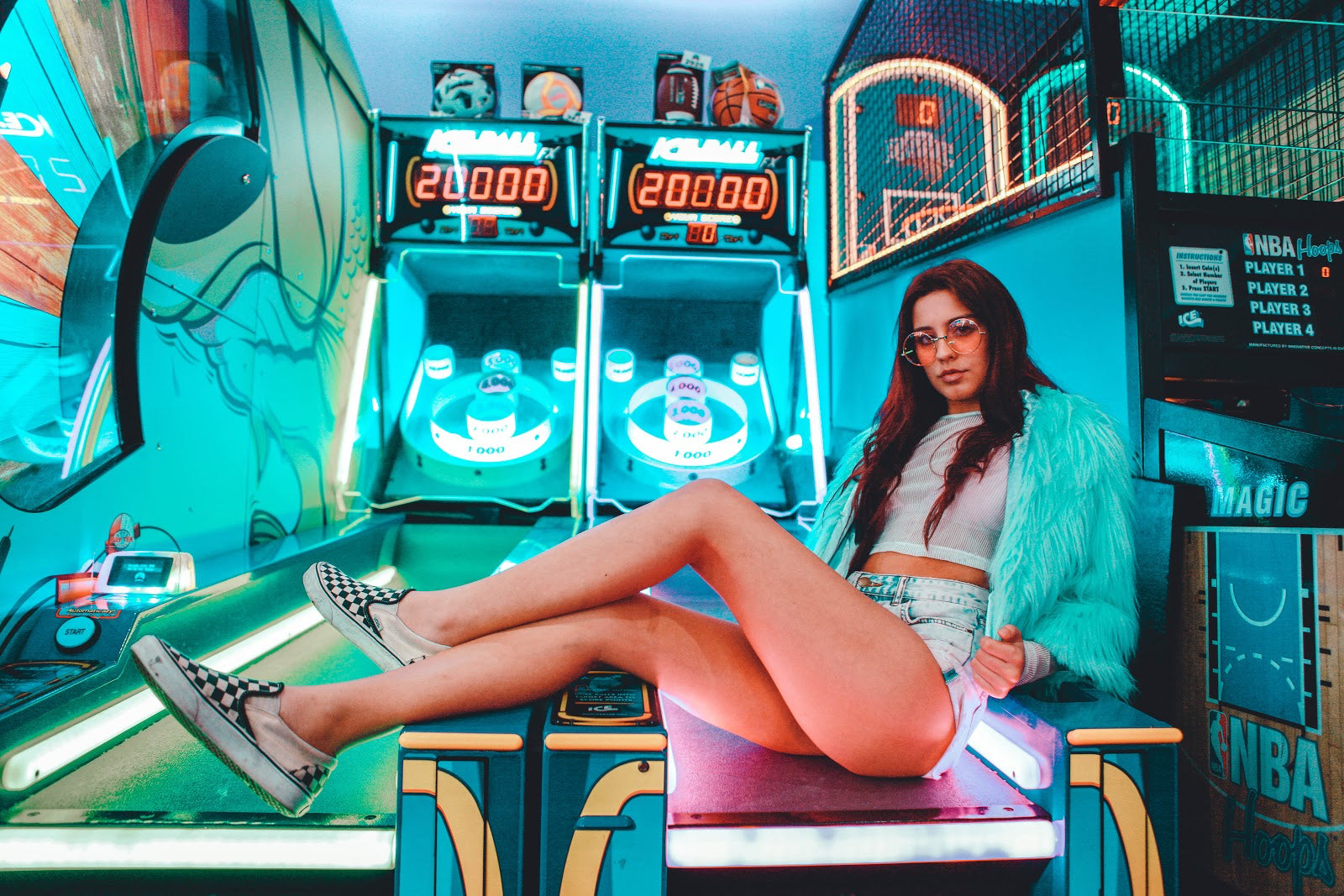 girl wearing shorts and faux fur sitting on iceball arcade game