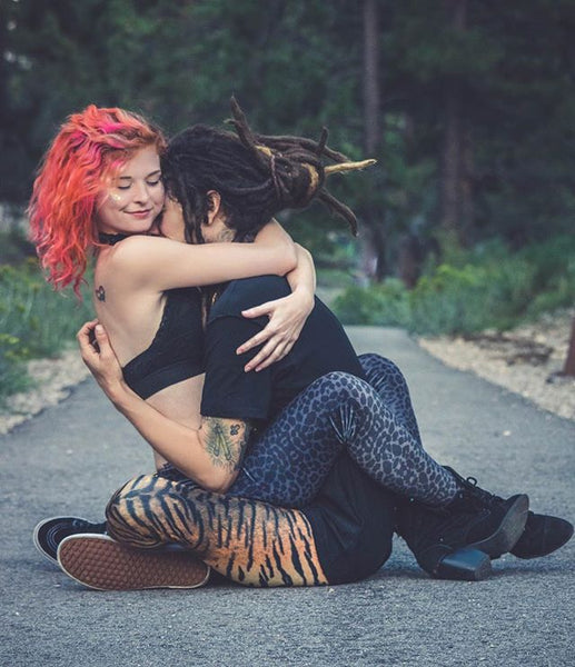 two people wearing spirithood leggings hugging each other while sitting down