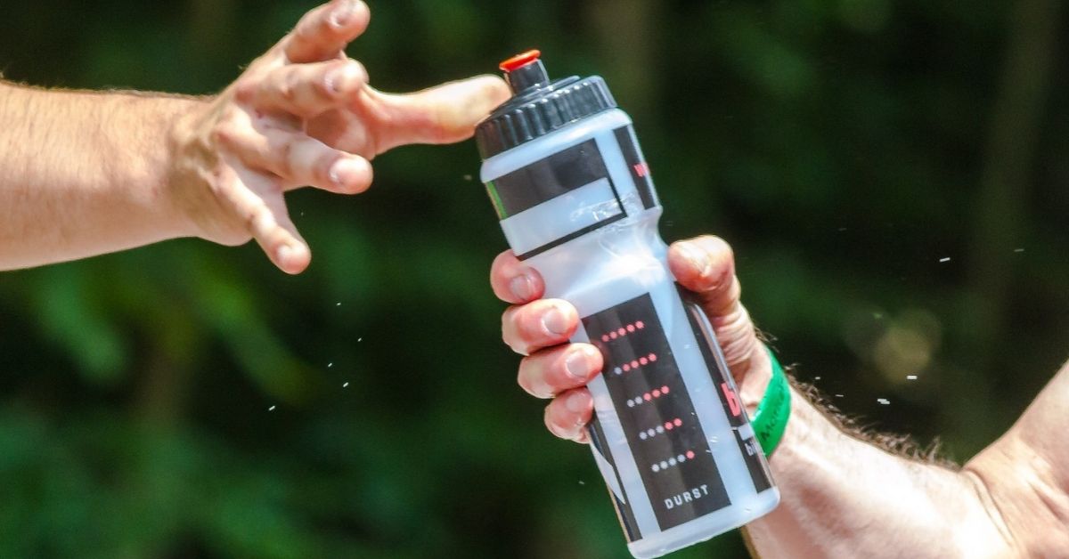 A water bottle being passed between two hands.