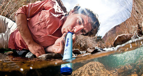 lifestraw man drinking from river