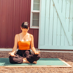 woman using Root Board doing Easy Pose (lotus variant)