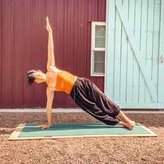 woman using yoga board doing Side Plank yoga pose