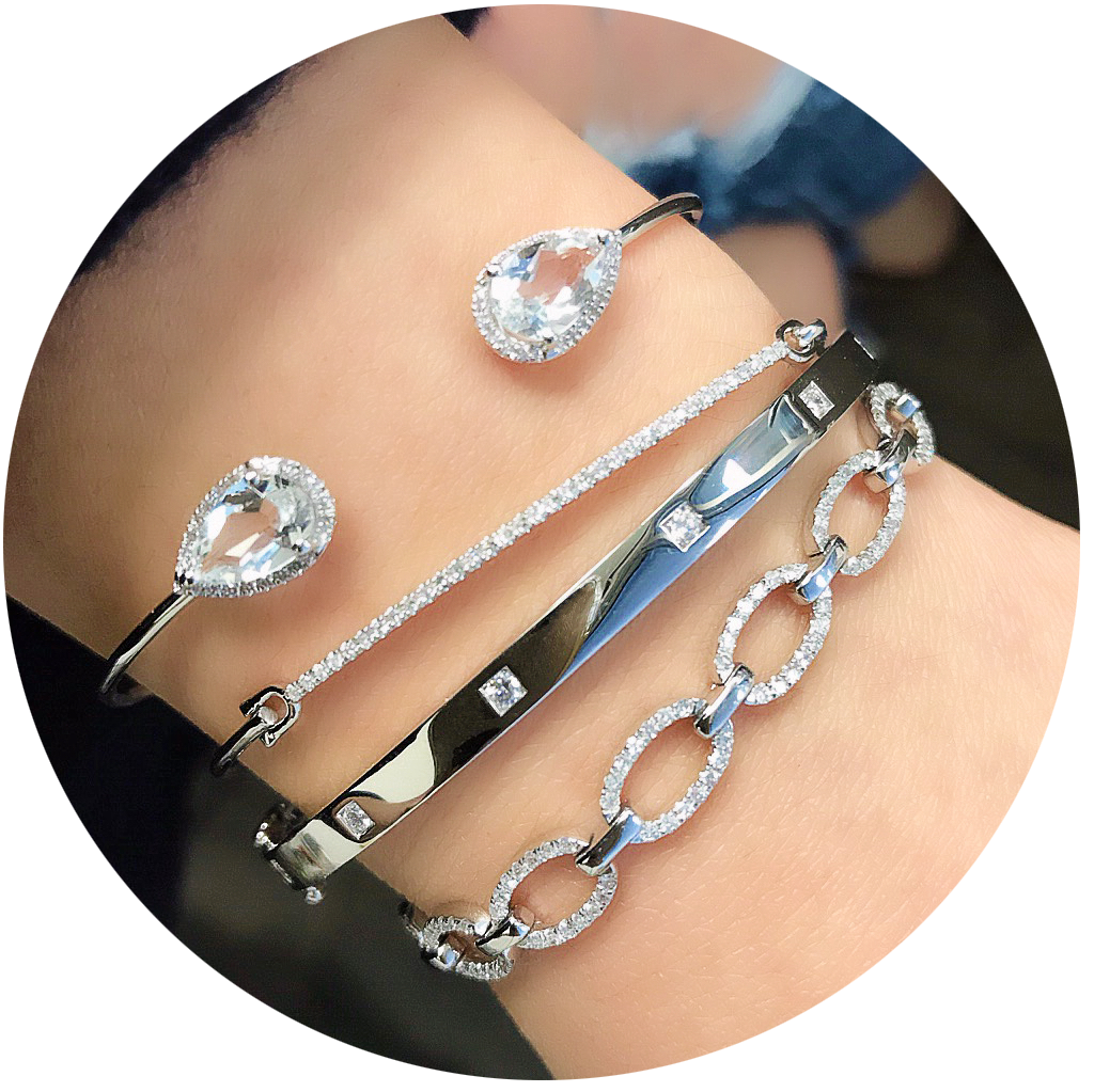 white topaz teardrop cuff bangle worn with other white gold bracelets in bridal style