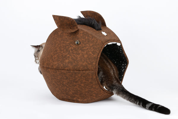 A cat sits with his head and tail sticking out of the novelty horse design Cat Ball® cat bed