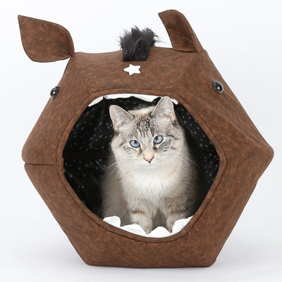 A small cat sits inside the novelty design horse Cat Ball cat bed