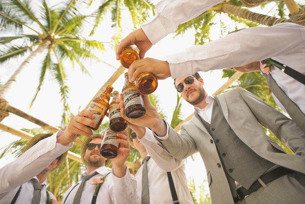 groomsmen drinking beer on beach