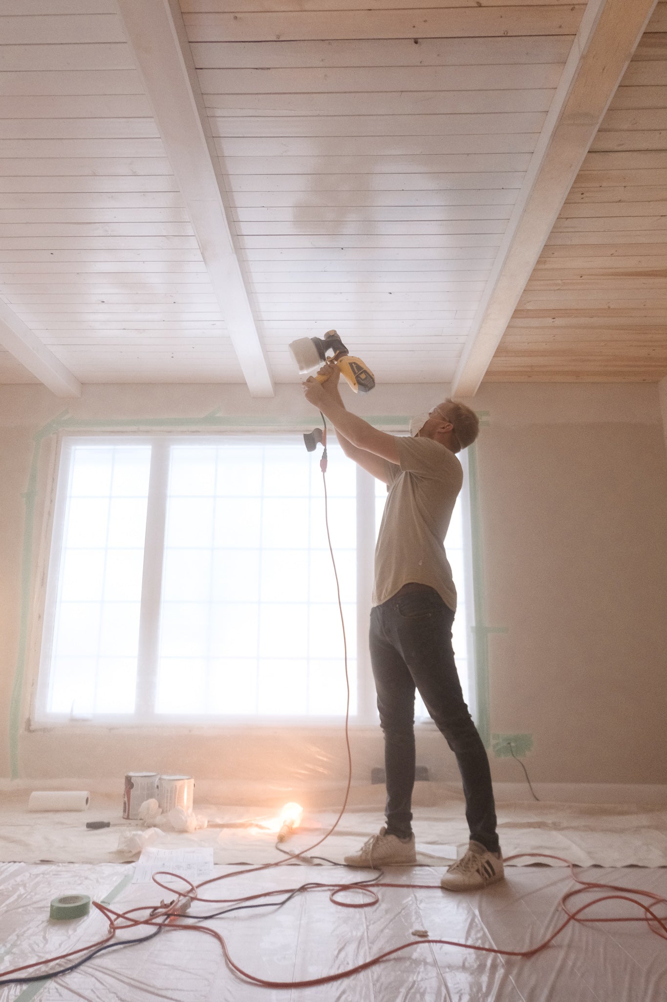 Painting shiplap ceiling with a paint sprayer