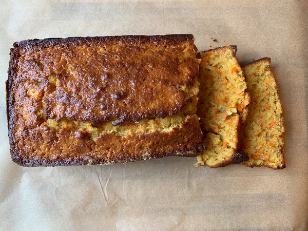 Carrot pineapple loaf cake with one end sliced showing the inside of two pieces.