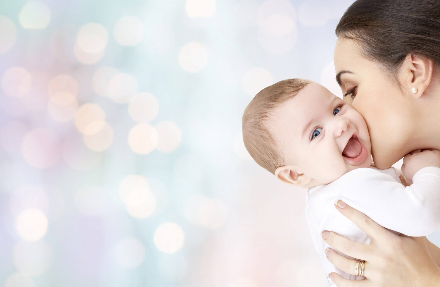 happy mother kissing adorable baby