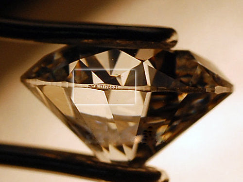 A diamond with its certification number engraved on girdle