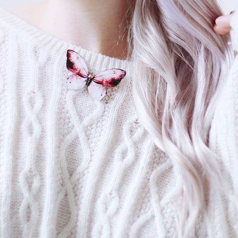 Pinning a butterfly brooch to your sweater.