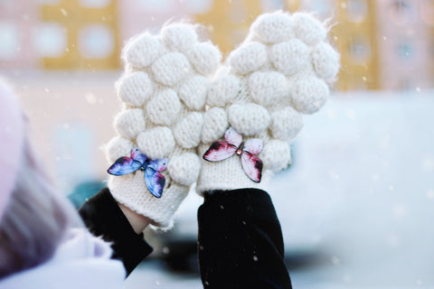 Wearing butterfly brooches on a pair of your favourite winter mittens.