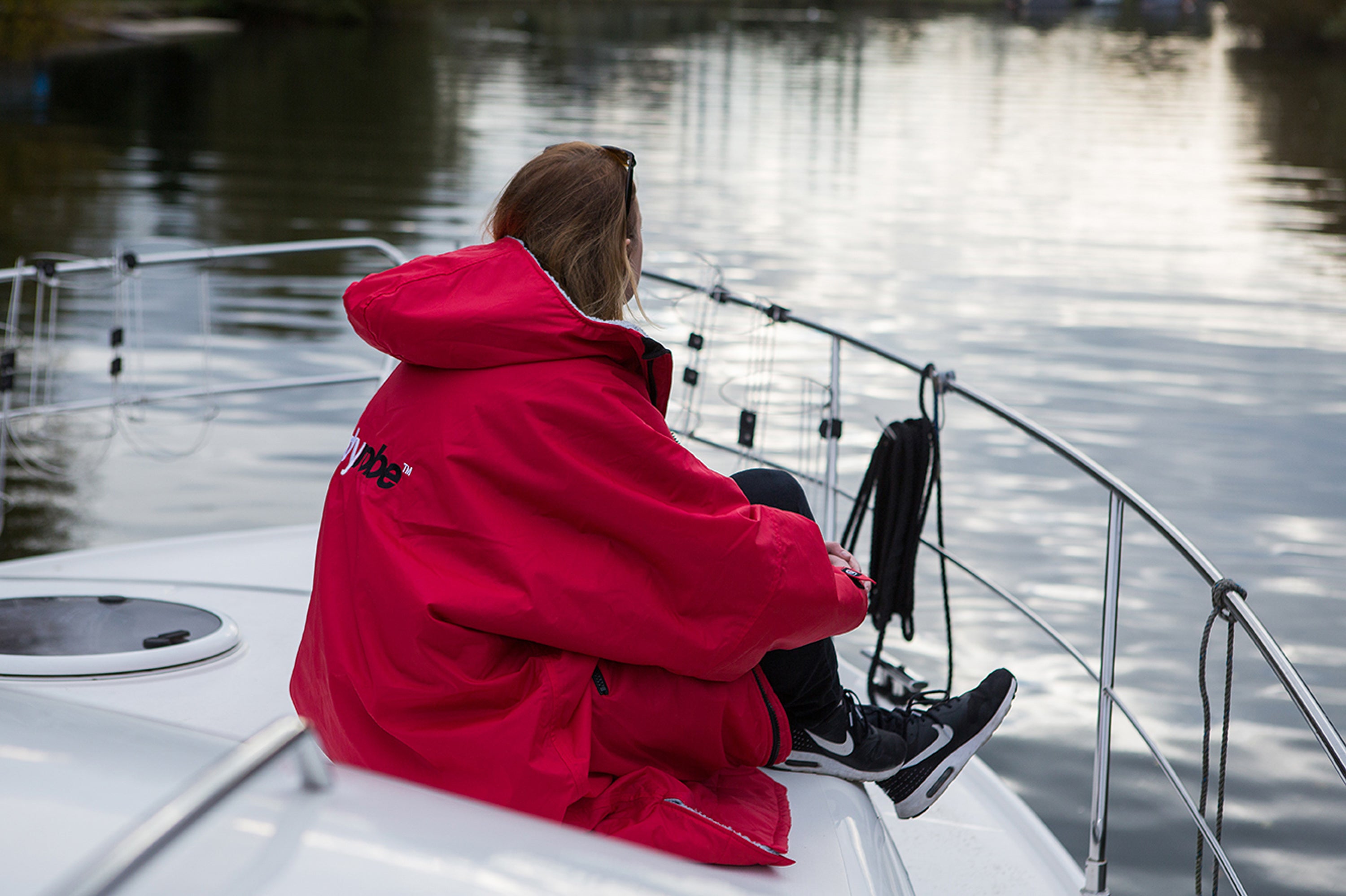 Woman sat on a boat in a dryrobe