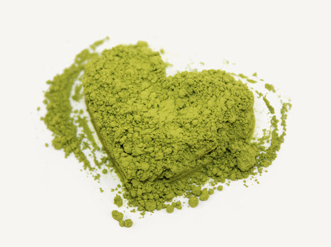 Photo of heart-shaped matcha green tea powder on white background
