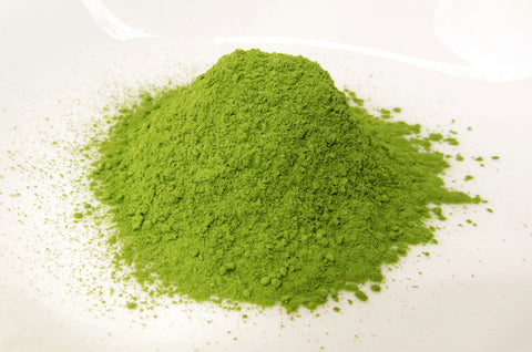 a photo of a small mound of matcha green tea powder on a light background
