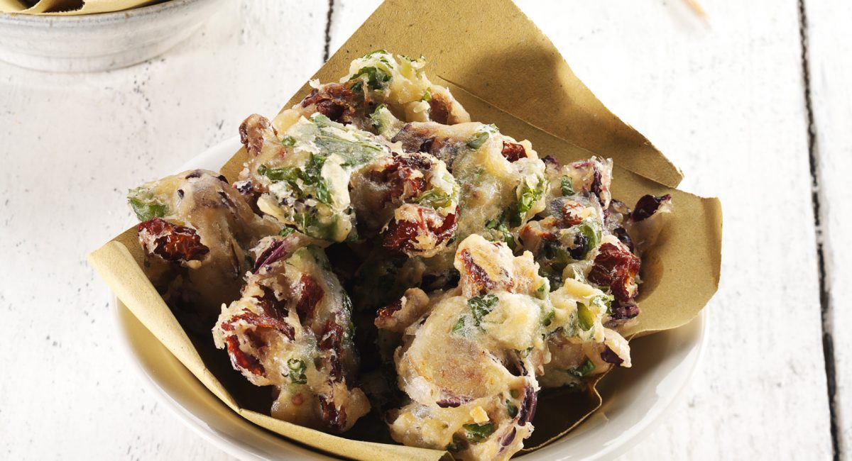 Bitter herb fritters with dried tomatoes in oil
