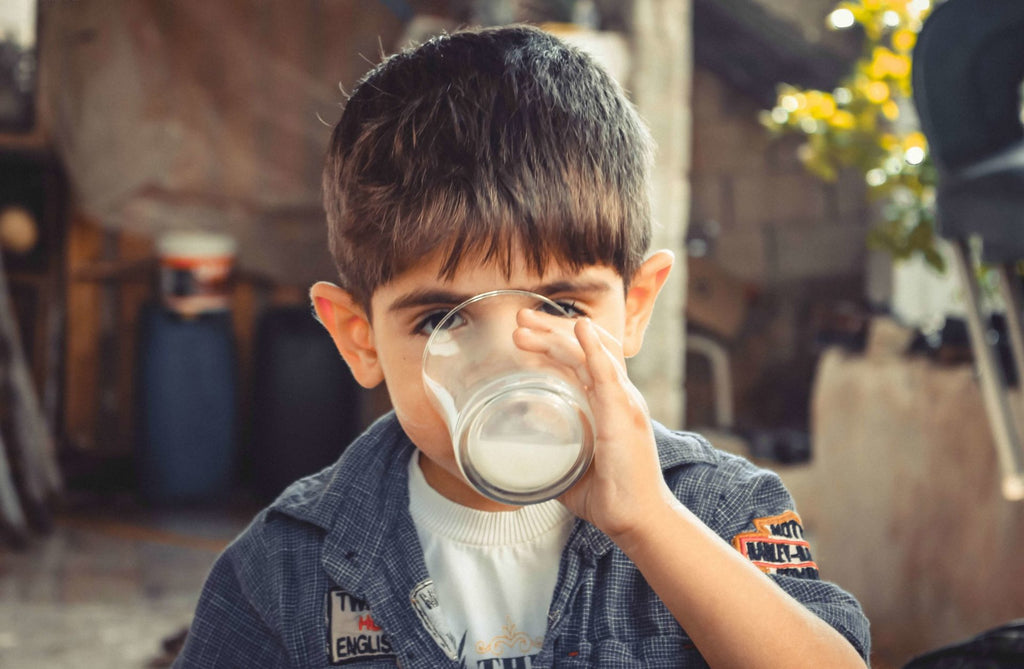 Child drinking milk with CBD oil