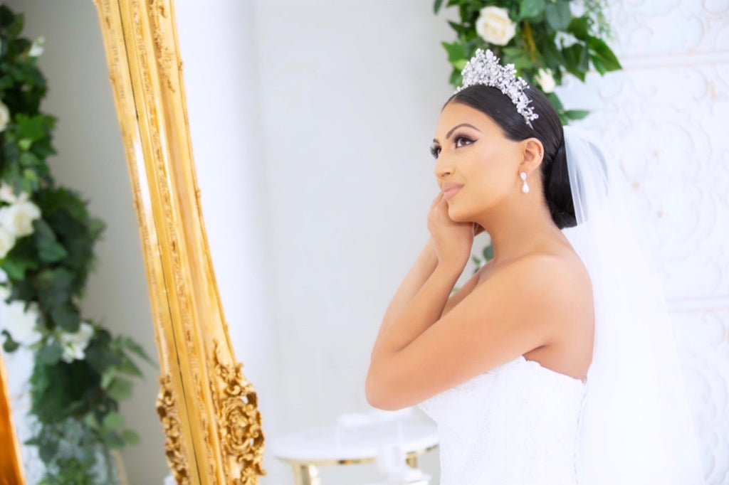 Georgette wearing our Katrina Crown looking in the mirror putting on her earrings