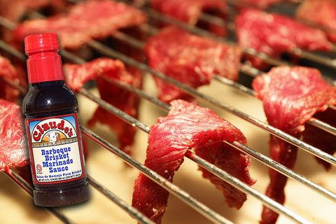 1/4 strips of beef on a drying rack with Claude's BBQ Brisket Marinade