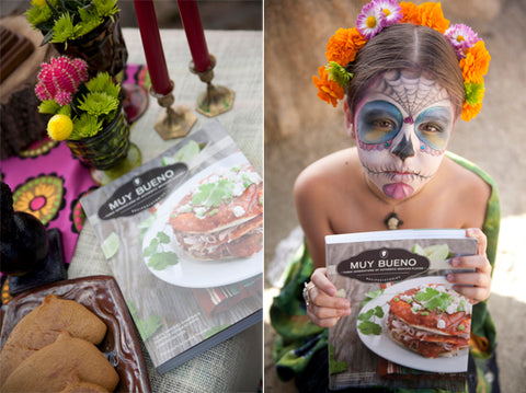 A Day of the Dead painted girl holds a Muy Bueno Cookbook