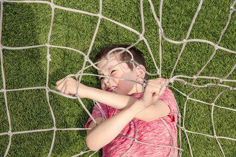 Boy stuck in soccer netting