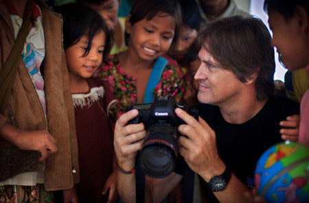 David Heath showing Burmese kids his photos