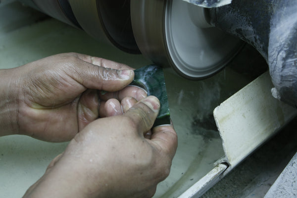 The stone is polished down to size and a rough shape using a polishing wheel. (Christine Lin/ Yun Boutique)