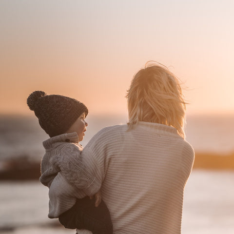 Mum holding a child by the beach