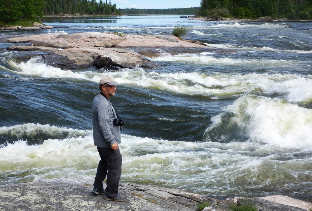 a paddler scouting rapids on the Churchill River 