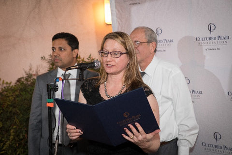 The CPAA’s Jennifer Heebner reads the names of winners of the most recent International Pearl Design Contest (IPDC). In the background are Anil Maloo (left), CPAA vice president and CEO of Baggins Pearls, and Aziz Basalely, CPAA president and CEO of Eliko Pearls.