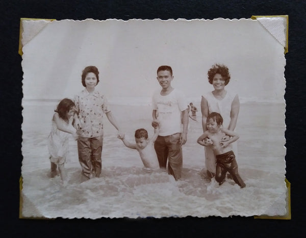 Three kids and adults in the 60s enjoying the beach in the Philippines.