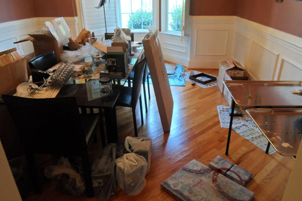 Messy artist studio takes over the entire house including the dining room.