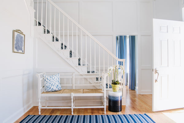 light and bright entry way from Jamie Merida Interiors - white bench and stairs with blue accents