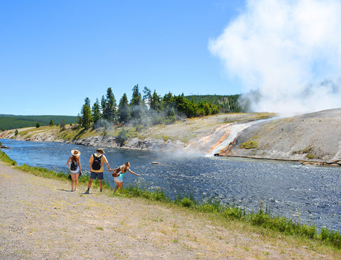 Family hiking next to Firehole River in Yellowstone National Park