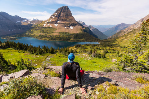 Man sitting with view of canyons in Glacier National Park