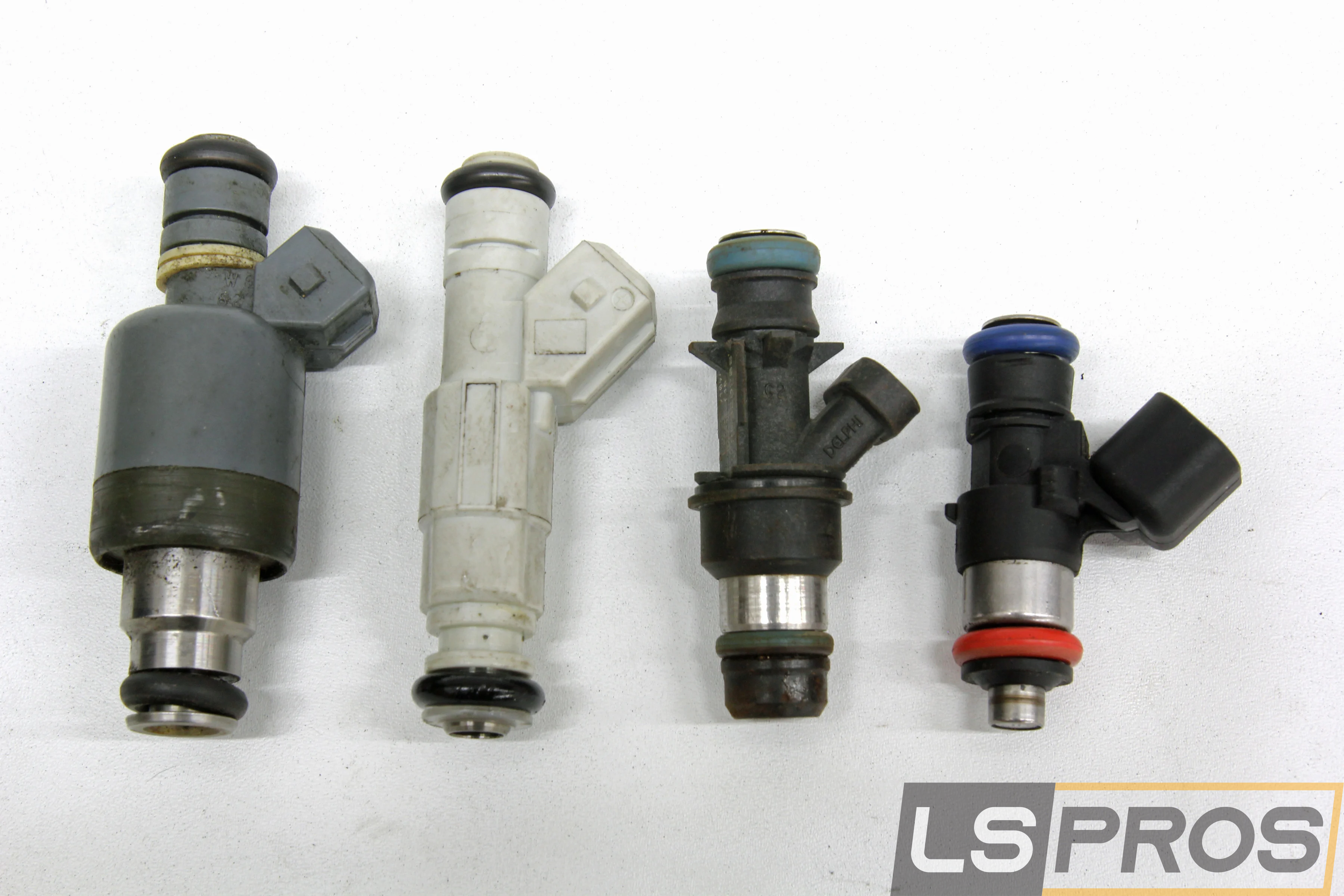 This injector family portrait includes four of the five popular GM fuel injectors. From left to right: original Bosch Jetronic EV1, the tall LS1 style followed by the early LS truck injector, and on the far right the late LS3 EV6 style. The one missing version is the late truck injector that is the same height as the early truck LS piece but using the EV6 electrical connector.