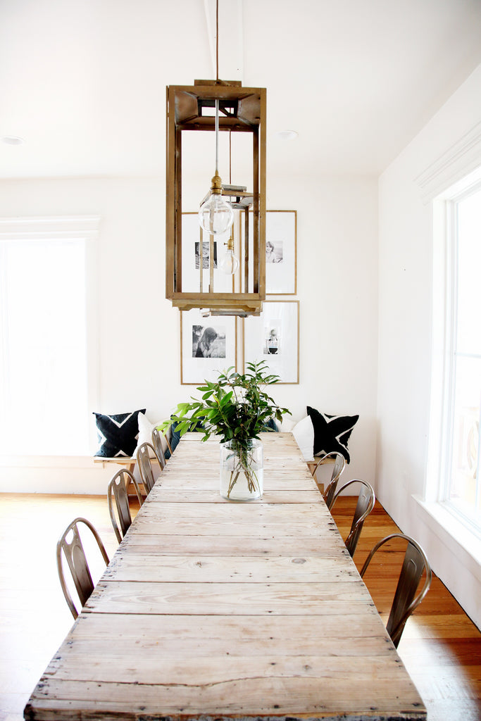 Dining room with a long wooden table and square hanging light
