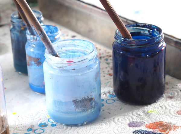 light and dark blue ebru paints in glass jars