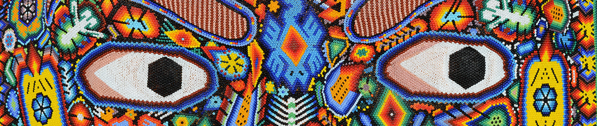 Parte de una escultura huichol multicolor con unos ojos grandes