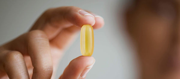 A person holding an Omega 3 supplement