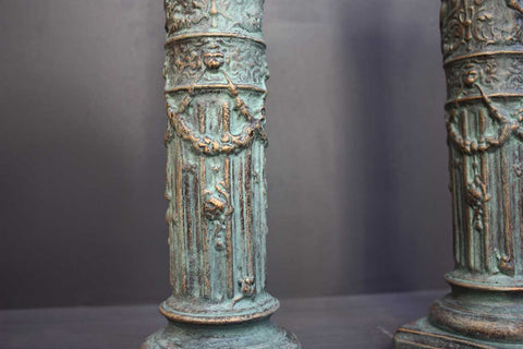 closeup photo of plaster cast of ornamental verdigris color candlestick with gray background