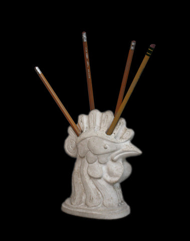 photo of plaster cast of stylized rooster head pencil holder with pencils inserted with a black background