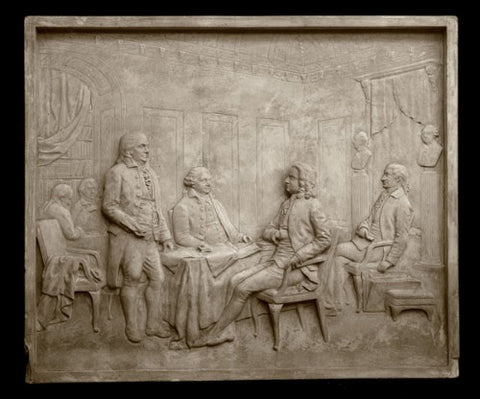 Photo of plaster cast sculpture relief of the signing of the Treaty of Paris depicting several men around a table including Benjamin Franklin and John Adams
