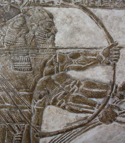 photo of plaster cast of ancient relief of two men in a chariot pulled by three horses and a wounded lion under their legs on a gray background