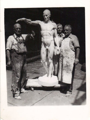 black and white photo of three men from P.P. Caproni and Brother posing with a large plaster cast of an ecorche