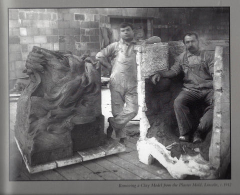 black and white photo of two men from P.P. Caproni and Brother posing with large plaster molds