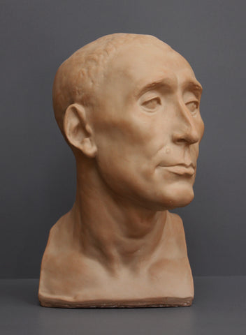 photo of plaster cast sculpture bust of man, namely Niccolo da Uzzano, in Terra Cotta Patina on a dark gray background