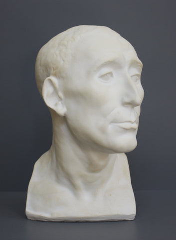 photo of plaster cast sculpture bust of man, namely Niccolo da Uzzano, in White Patina on a dark gray background