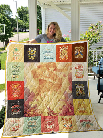 Photo of woman holding up a patchwork quilt on a porch